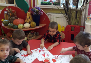 Dzieci malują farbami kolorowankę "Muchomor"